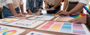 Grafik tasarımcı beyin fırtınası logosu ve grafik sanat yoğun yaratıcı stüdyo atölyesinde. Yaratıcı tasarım için çalışma masasında deney ve beyin fırtınası renk paleti ve desen. Panorama çekimi. İnceleyin