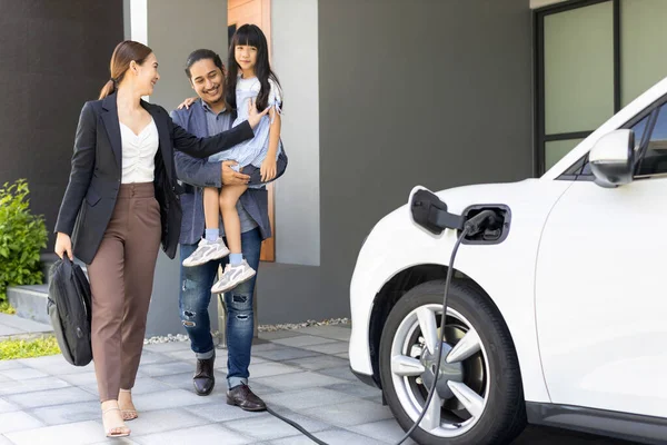 Progressive Young Parents Daughter Electric Vehicle Home Charging Station Green — Stockfoto