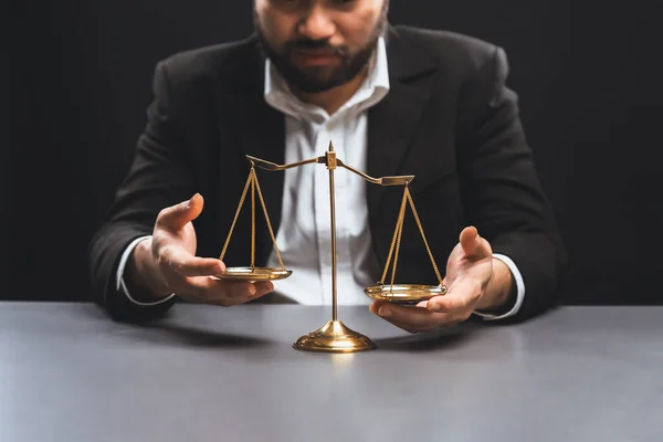 stock image Lawyer or judge in formal black suit hold unbalanced scale with expression of disappointment trying to fix imbalance as anti-injustice concept to fight against corruption of legal system. equility