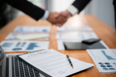 El sıkışma geçmişi bulanık olan ve masadaki pano kağıdına odaklan. İş ortakları arasında başarılı bir iş birliği ve finansal teknoloji anlaşması. Coşkulu
