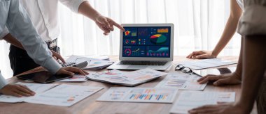 Panorama analist ekibi, FBI Fintech 'i kullanarak dizüstü bilgisayarla mali raporu analiz ediyor. İş adamları iş görüşü için dizüstü bilgisayarda gösterilen kontrol panelini inceliyor. İnceleyin