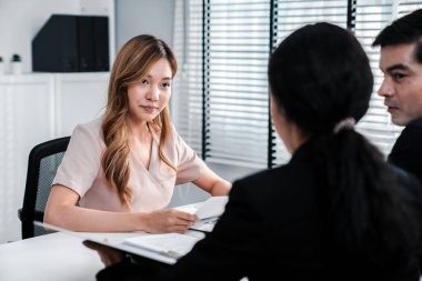 A young female asian candidate tries to impress her interviewer by being competent. International company, multicultural environment in workplace.