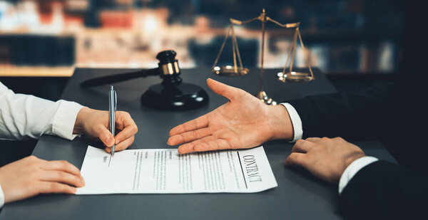 Lawyer signing contract, professional lawyer in law firm library drafting legal document or contract agreement ensuring lawful protection for clients dispute as fairness advocate concept. Equilibrium