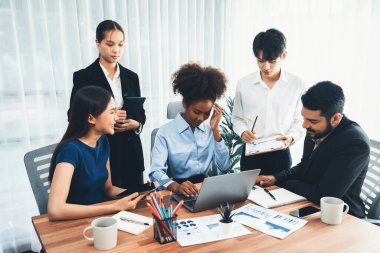 Çok ırklı analist ekibi toplantı masasındaki finansal verileri analiz etmek için BI Fintech yazılımı kullanıyor. Finansal konsol veri ekranında pazarlama göstergesi için analiz edilmiş grafikle birlikte. Uyum