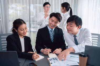 Harmony in office concept as business people analyzing dashboard paper together in workplace. Young colleagues give ideas at manager desk for discussion or strategy planning about project.