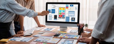 Dizüstü bilgisayar ekranında mobil uygulama için UI ve UX tasarımları tasarlayan ön uç geliştirici ekibin panorama görüntüsü. Kullanıcı dostu UI tasarımı için kullanıcı arayüzü geliştirme ekibi planlama. İnceleyin