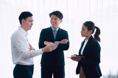 Mentor, manager advice younger colleagues in workplace. Businesspeople discussing or planning financial project strategy, talking together for harmony and strong teamwork in office concept.