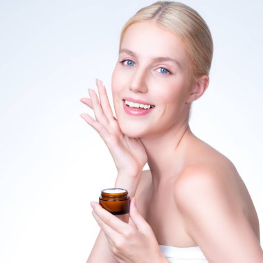 Closeup personable beautiful perfect clean skin soft makeup woman finger applying moisturizer cream on her face for anti aging wrinkle. Facial rejuvenation with expressive hand gesture putting cream.