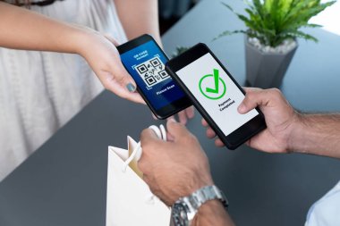 Parasız ödeme taraması için QR kodu ekranda görüntülendi. Kapalı eller, mobil uygulamadan elektronik işlem yoluyla para aktarmak için akıllı telefonu tutuyor. Hızlı ödeme için barkod teknolojisi. Coşkulu