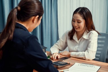 Temsilciyle ev kredisi sözleşmesini gözden geçiriyorum. Mali belgeleri ve vergi oranlarını, mülkiyet sahibi olmak için hesap makinesiyle analiz ediyorum. Yeni ev alımı ve finansman için anahtar imza. Coşkulu.