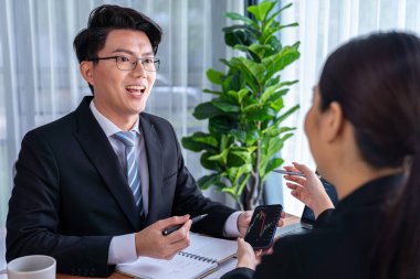 Risk yönetimi ya da finansal ekip, akıllı telefondan hisse senedi grafiklerini izlerken müşteri portföyü üzerinde çalışır ve analiz eder. Ofisinde veri analizi olan hisse senedi yatırım şirketi. Sevinçli.