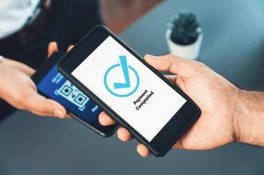 Parasız ödeme taraması için QR kodu ekranda görüntülendi. Kapalı eller, mobil uygulamadan elektronik işlem yoluyla para aktarmak için akıllı telefonu tutuyor. Hızlı ödeme için barkod teknolojisi. Coşkulu