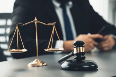Hukuk bürosundaki masabaşında çalışan avukatın bulanık arka planına odaklan. Gavel, kanun koyucu ve avukatın adil ve eşit karar vermesi için çekiç. Eşitlik