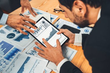 Analist ekibi, tablet ekranında veri bilimi yazılım görüntüsü kullanarak dijital paneldeki finansal verileri analiz ediyor, grafiği ve grafiği analiz ediyor. İş zekası ve Fintech. Coşkulu