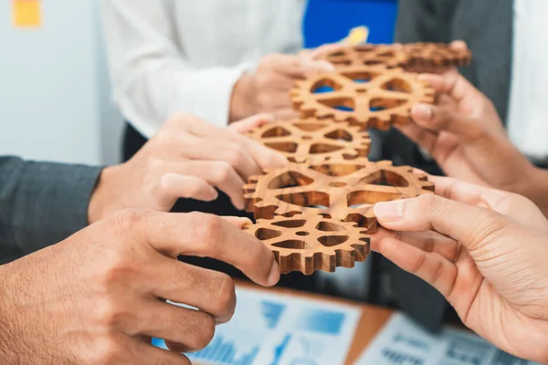 stock image Office worker holding cog wheel as unity and teamwork in corporate workplace concept. Diverse colleague business people showing symbol of visionary system and mechanism for business success. Concord