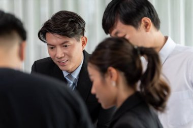 Mentor, manager advice younger colleagues in workplace. Businesspeople discussing or planning financial project strategy, talking together for harmony and strong teamwork in office concept.
