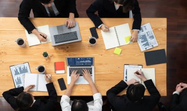 Top view manager or office worker give presentation in harmony conference room to business colleague, BI data dashboard on screen and pile of financial analyzed data reports on meeting table.