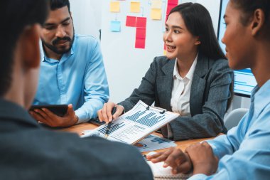 Çok ırklı analist ekibi toplantı masasındaki mali raporu analiz etmek için BI gösterge tablosunu kullanıyor. Çeşitli iş adamlarından oluşan bir grup, iş pazarlama kararı için FIntech 'in veri analizini kullanır. Uyum