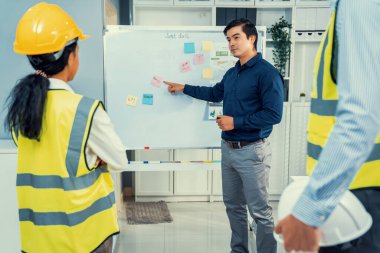 A team of investor and competent engineers brainstorming on the whiteboard to find new ideas and making plans. The idea of a team gather ideas together.