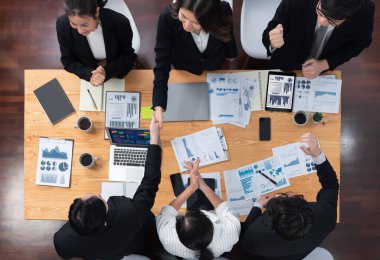 Top-view business team of financial data analysis meeting with business intelligence, report paper and dashboard on laptop for marketing strategy. Business people working together in office of harmony