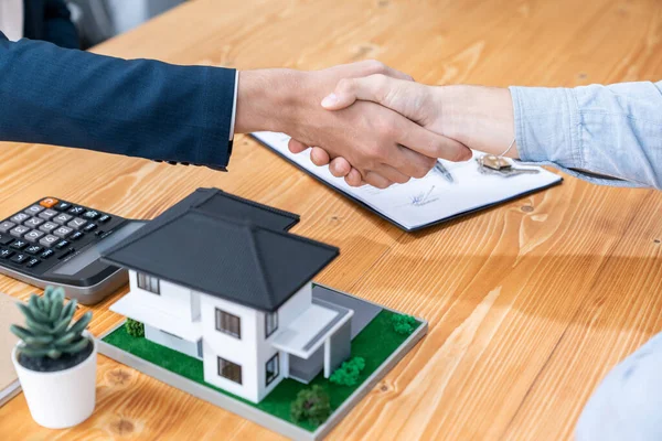 Finalizing house loan agreement with handshake, buyer and real estate agent celebrate accomplishment of property ownership with sense of satisfaction. New home owner shake hand with broker. Entity