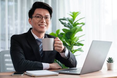 Ofis masası çalışma alanı portresi için dizüstü bilgisayarda çalışan bir iş adamı. Akıllı yönetici finansal iş verilerini araştırıyor ya da masada bilgisayarla stratejik iş pazarlaması planlıyor. Sevinçli.