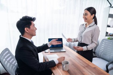 Görüşmeci ve aday arasındaki iş görüşmesi. İK müdürü aday niteliklerini ve özgeçmişli iş başvurusunu soruyor. Başvuru sahibinin işi. Sevinçli.