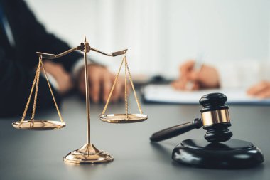 Hukuk bürosundaki masabaşında çalışan avukatın bulanık arka planına odaklan. Gavel, kanun koyucu ve avukatın adil ve eşit karar vermesi için çekiç. Eşitlik