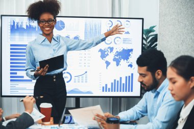 Genç Afrikalı iş kadını modern toplantıda TV ekranında veri analizi paneli sunuyor. Bir grup iş adamıyla konferans odasında iş sunumu. Uyum