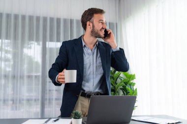 Çalışkan ve çalışkan iş adamı, cep telefonuyla müşterileriyle konuşurken, modern çoklu görev yapan ofis çalışanı yaşam tarzını sergiliyor. Varlık