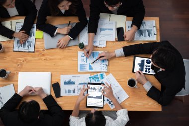 Top-view business team of financial data analysis meeting with business intelligence, report paper and dashboard on laptop for marketing strategy. Business people working together in office of harmony