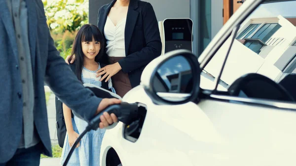 Progressive Young Parents Daughter Electric Vehicle Home Charging Station Green — Zdjęcie stockowe