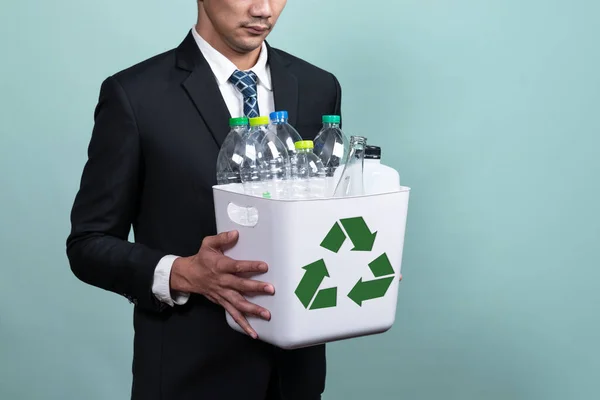 ビジネスマンは 隔離された背景にプラスチックボトルで満たされたごみ箱を保持します 緑の環境とコミュニティのための企業責任 廃棄物分離と管理の概念 Alter — ストック写真