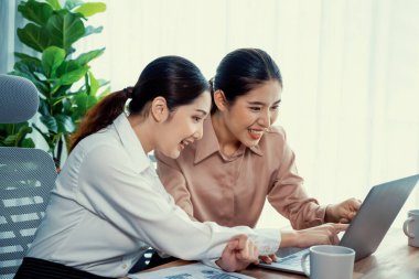 Modern ofis çalışma alanında iş birliği yapan iki genç ofis çalışanı, modern ofis çalışanı olarak profesyonelliklerini sergileyerek, dizüstü bilgisayarda tartışıyorlar ve birlikte çalışıyorlar. Coşkulu.