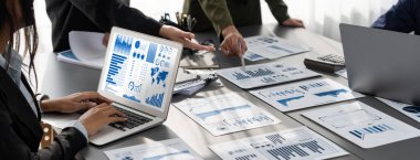 Panorama analist ekibi, FBI Fintech 'i kullanarak dizüstü bilgisayarla mali raporu analiz ediyor. İş adamları iş görüşü için dizüstü bilgisayarda gösterilen BI veri torpidosunu inceliyor. Dahi.