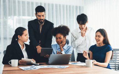 Çok ırklı analist ekibi toplantı masasındaki mali raporu analiz etmek için BI gösterge tablosunu kullanıyor. Çeşitli iş adamlarından oluşan bir grup, FIntech 'in veri analizini başarılı iş pazarlaması için kullanır. Uyum