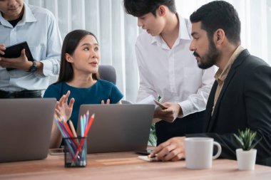 Profesyonel Asyalı çalışanlar, şirket ofisinde takım olarak çalışarak iş planları ve bilgisayarla başarılı olmak için verileri tartışırlar. Modern ofis çalışanı takım çalışması konsepti. Uyum