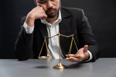 Resmi siyah davadaki avukat ya da yargıç, dengesizliği adalet sistemindeki yolsuzlukla mücadele için adaletsizliğe karşı bir kavram olarak düzeltmeye çalışırken hayal kırıklığı ifadesiyle dengesizlik gösteriyor. denge