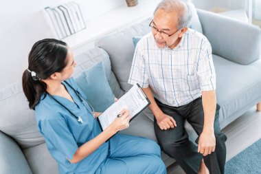 A young female doctor inquires about personal information of a contented senior at home. Medical care for the elderly, elderly illness, and nursing homes, home care.