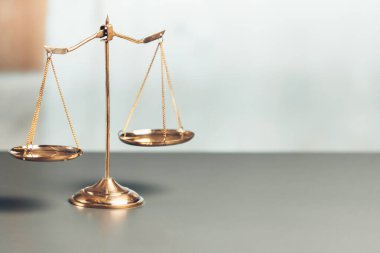 Mahkeme kütüphanesinin arka planında adalet ve adalet sembolü olarak parlak altın dengeli bir terazi. Avukat ve avukatın adil ve eşitlik kararı için terazi uygulayın. denge