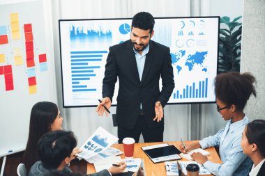 Pazarlama stratejisi için modern toplantıda veri analizi paneli ekranında sunan bir işadamı. Bir grup iş adamıyla konferans odasında iş sunumu. Uyum