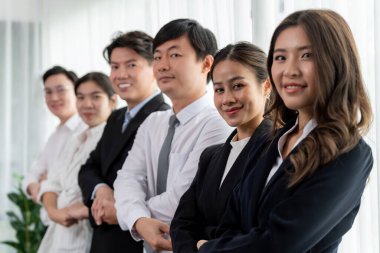 Cohesive group of businesspeople standing in row, holding hand in line together after meeting to promote harmony in workplace. Asian office workers strong teamwork and unity concept.
