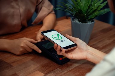 QR kodu parasız ödeme taraması için ekranda gösterilir. Kapalı eller, mobil uygulamadan elektronik işlem yoluyla para aktarmak için akıllı telefonu tutuyor. Hızlı ödeme için barkod teknolojisi. Coşkulu.
