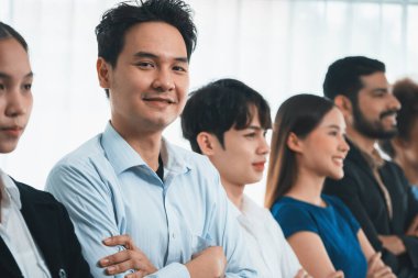 Profesyonel iş adamlarından oluşan çeşitli gruplar modern kurumsal ofiste çapraz kol hareketi ile sırada bekliyor. Mutlu ve gülümseyen, çok ırklı ofis çalışanı ekip birleşmesi ve birlikte başarılı. Uyum