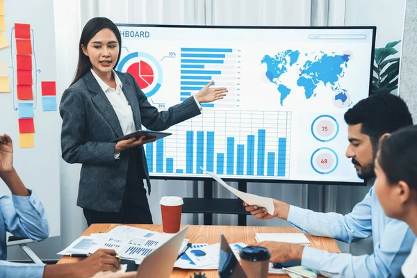 stock image Young asian businesswoman presenting data analysis dashboard on TV screen in modern meeting. Business presentation with group of business people in conference room. Concord