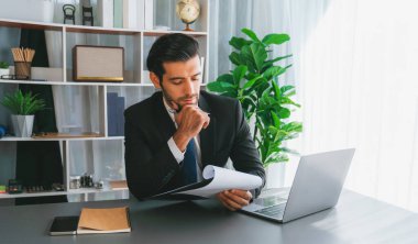 Modern ofis masasındaki modern profesyonel iş adamı çalışmak ve notlar yazmak için dizüstü bilgisayar kullanıyor. Ofisinde bilgisayar defteri üzerinde çalışan çalışkan bir ofis çalışanı. coşkulu