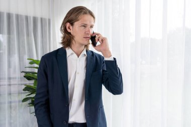 Çalışkan iş adamı, modern ofiste güvenilir bir şekilde müşteriye ikna edici satış çağrıları yapıyor. Ofis çalışanı telefonda konuşuyor ve iş arkadaşlarıyla iş görüşmesi yapıyor. Varlık