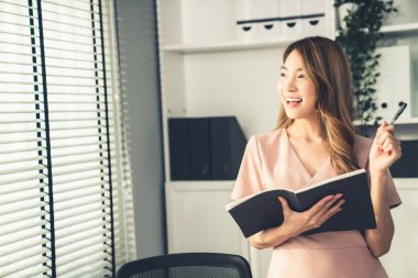 Young competent office lady, intern, secretary holding a log in office room. Concept of various career for office working. Concept of diverse office careers.