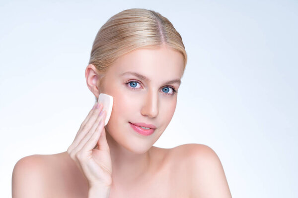 Личная красивая натуральная женщина мягкого макияжа с использованием пудры для концепции макияжа лица. Подушка фонда применения на лицо молодой девушки на изолированном фоне.