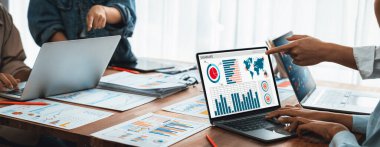 Panorama analist ekibi, FBI Fintech 'i kullanarak dizüstü bilgisayarla mali raporu analiz ediyor. İş adamları iş görüşü için dizüstü bilgisayarda gösterilen kontrol panelini inceliyor. İnceleyin